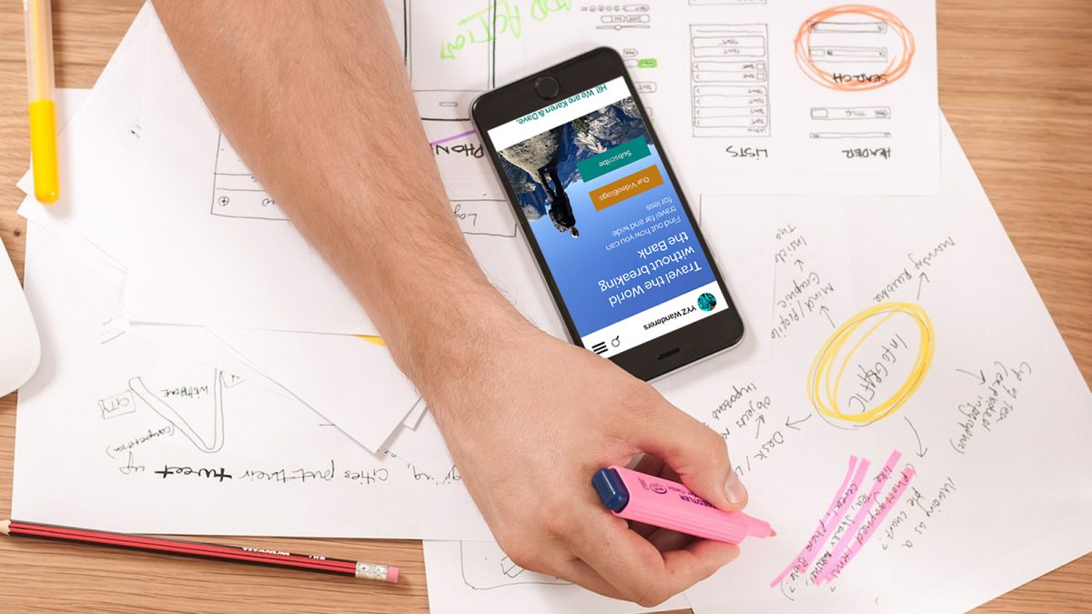 Taking notes, a cell phone on the desk with the YYZ Wanderers website on screen